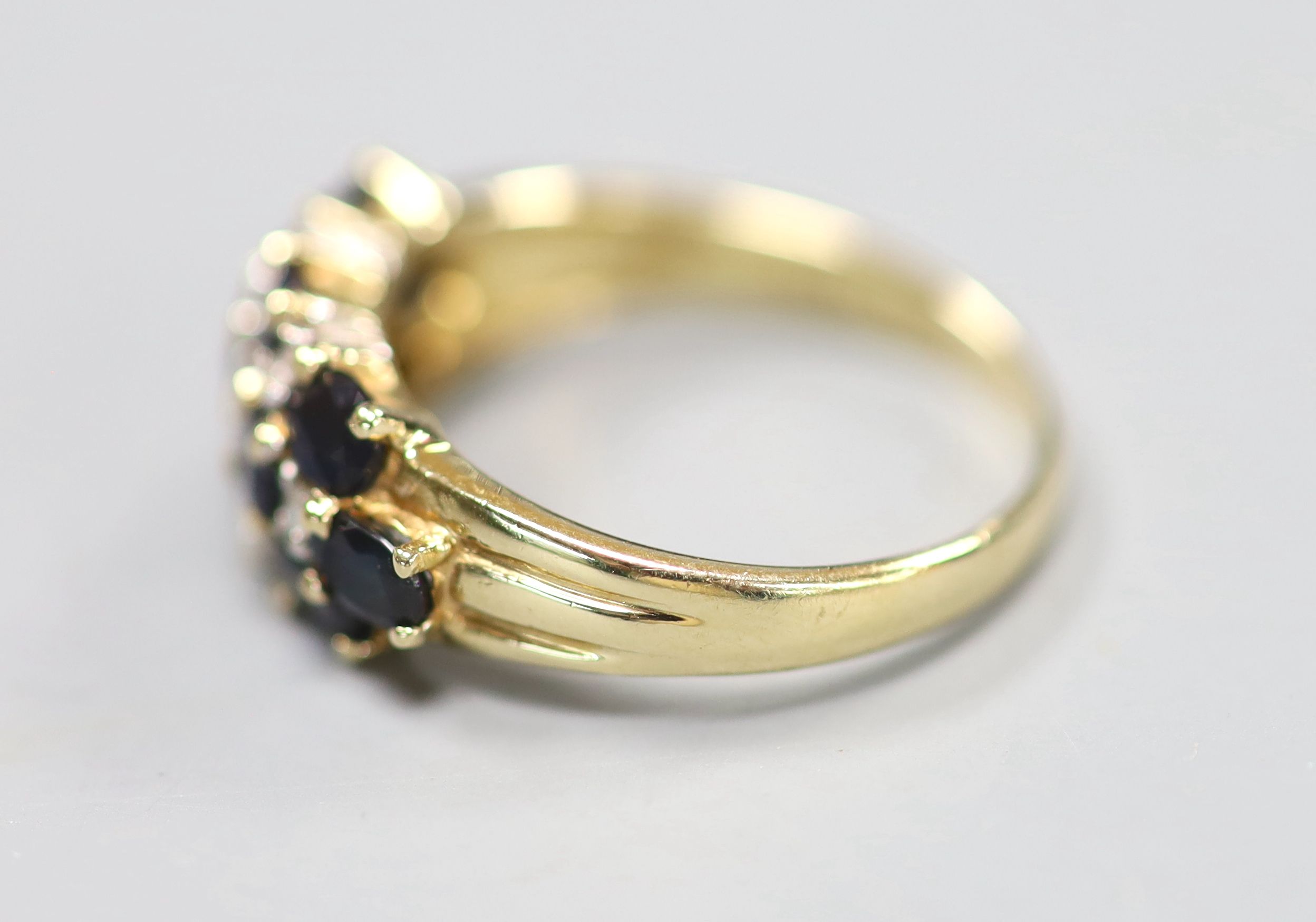 A modern 14ct gold, sapphire and diamond cluster half hoop dress ring, size Q, gross 4 grams.